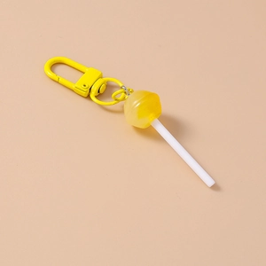 Detail of creative yellow lollipop keychain with metallic carabiner and realistic food texture