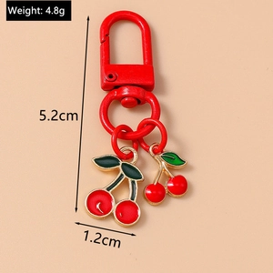 Macro view of cherry-shaped keychain showing dimensions 5.2cm and 4.8g weight