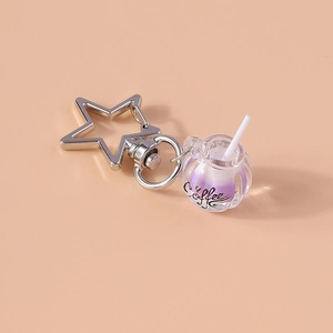 Close-up of a purple glow-in-the-dark coffee cup keychain with a silver star clasp