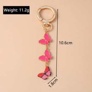 Détail du porte-clés papillon en émail rose avec crochet doré et design léger de 11,2 g