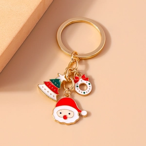 Detail of Christmas keychain with Santa, tree and wreath charms on golden ring