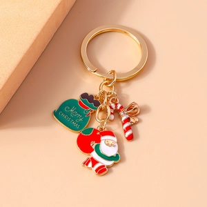 Detail of Christmas keychain with Santa, gift bag and candy cane pendants on gold ring