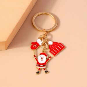 Macro view of Christmas keychain with Santa, red glove and striped hat alloy charms
