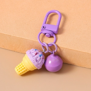 Detail eines lila Eiscreme-Schlüsselanhängers mit Glocke auf orangefarbenem Grund