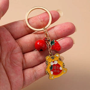 Détail du porte-clés tigre mignon avec clochette rouge et breloque fraise