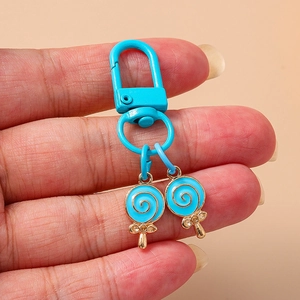 Handheld light blue double lollipop keychain with metallic spiral texture and sparkling crystals