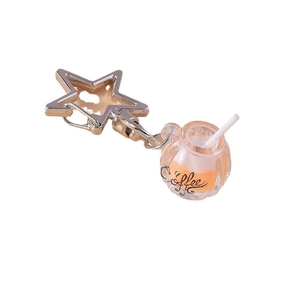 Glow in the dark orange coffee cup keychain with star-shaped ring on white background