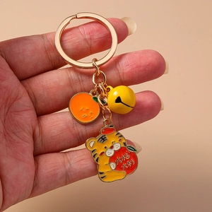 Vue détaillée du porte-clés tigre mignon avec pendentif orange et décoration de cloche dorée