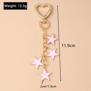 Detail view of pink enamel star charms on a gold heart-shaped keychain with dimension labels
