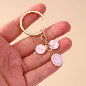 Détail du porte-clés montre Mom doré avec breloques en émail rose et anneau