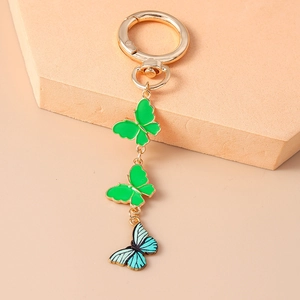 Détail de trois papillons en émail coloré sur un fermoir doré pour porte-clés design