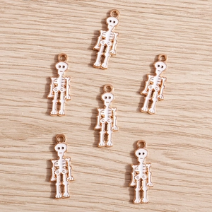 Détail macro de pendentifs squelettes en émail blanc et placage doré pour bijoux faits main