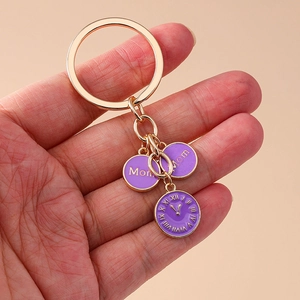 Détail du porte-clés doré avec pendentifs Mom en émail violet et motif horloge