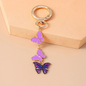 Détail d'un joli porte-clés papillon en émail avec fermoir doré et pendentifs dégradés