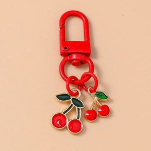 Detailed view of dual red cherry keychain pendant with large spring hook and green leaf