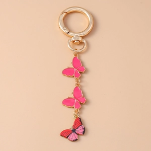 Détail de pendentifs papillons colorés en émail et mousqueton doré de porte-clés