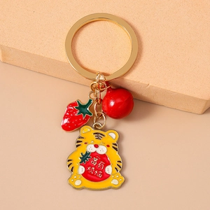 Détail du porte-clés en émail tigre et fraise avec anneau en métal doré brillant