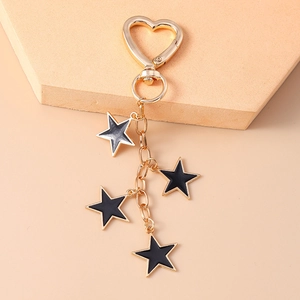 Detail of star-shaped keychain with black drip oil finish and heart buckle charm