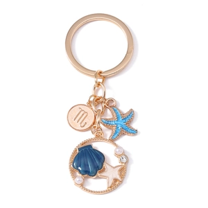 Golden starfish and shell keychain with Scorpio constellation disc and white pearls