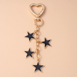 Detail of gold heart spring clasp with black enamel star pendants on a gold chain