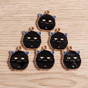 Détail d'un lot de 6 breloques de dessin animé avec émail noir et alliage d'or sur bois