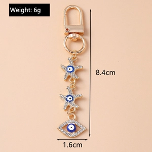 Detail of evil eye keychain with starfish charms and dimensions 8.4cm by 1.6cm