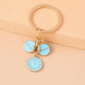 Détail du porte-clés doré Mom avec horloge et pendentifs en émail bleu clair