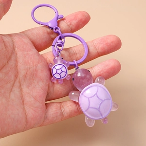 Close-up of cute purple resin turtle keychain with translucent jelly texture and metal clip