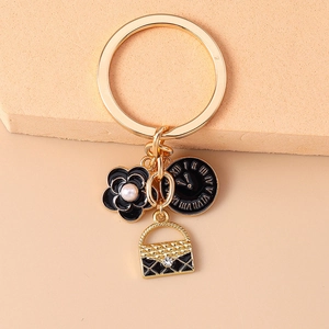 Creative keychain featuring a camellia flower, clock charm and quilted handbag pendant
