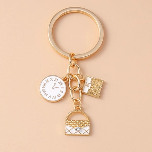 Detail of golden clock keychain with checkered handbag charm and rhinestones decoration