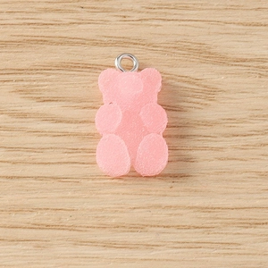 Macro view of pink resin gummy bear pendant with frosted texture and silver metal ring