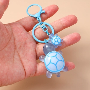 Close-up of cute light blue resin turtle keychain set with lobster clasp for backpacks
