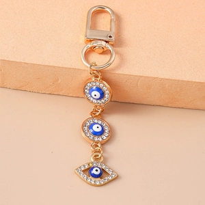 Detail of golden Evil Eye keychain with blue enamel and sparkling crystal pavé