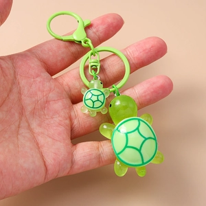 Detail of green resin mother-and-child turtle keychain with matching metal ring