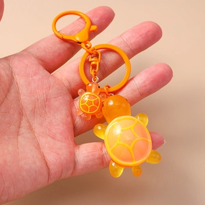 Detail of cute orange resin turtle keychains with glossy finish and metal ring