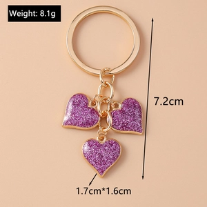 Detail view of purple glitter heart keychain showing gold ring and dimensions