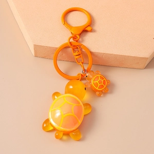 Detail view of dual orange resin turtle charms with translucent texture and geometric pattern