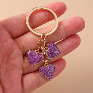 Golden heart keychain with three purple glitter pendants for backpacks and bags