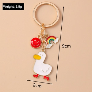 Detail view of cartoon duck keychain with rainbow and smiley charm on gold ring