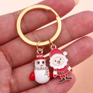 Detail of Christmas snowman and Santa Claus metal pendants on a gold keychain