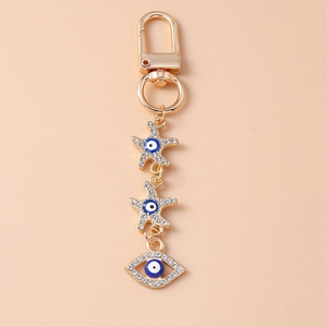 Detail of gold starfish and evil eye charms with sparkling crystals on a keychain