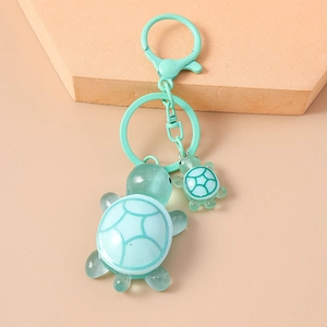 Detail of green resin turtle keychains with crackle pattern and matching metal hooks