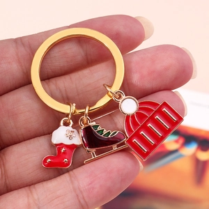 Christmas keychain with red Santa sock, ice skate, and winter hat pendants on gold ring
