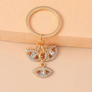 Detail eines goldenen Evil Eye Schlüsselanhängers mit funkelnden Strasssteinen