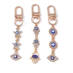 Golden Hamsa hand and starfish keychains with blue evil eye charms and rhinestones