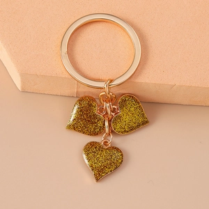 Detail shot of the golden glitter heart keychain showing sparkling pendants and key ring