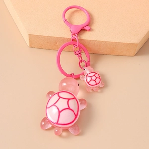 Detailed view of pink resin turtle keychain with large and small pendants and metal clasp