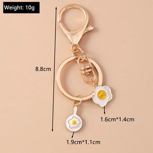 Detailed size view of a golden frying pan and egg keychain with measurements and weight