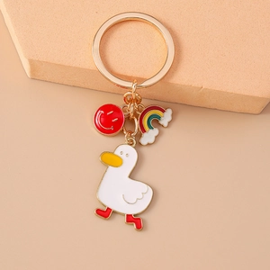Detail of cartoon duck keychain with red smiley face charm and rainbow cloud pendant