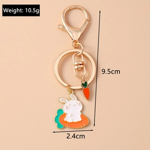 Detail of creative cartoon white rabbit on carrot keychain with golden lobster clasp and charm
